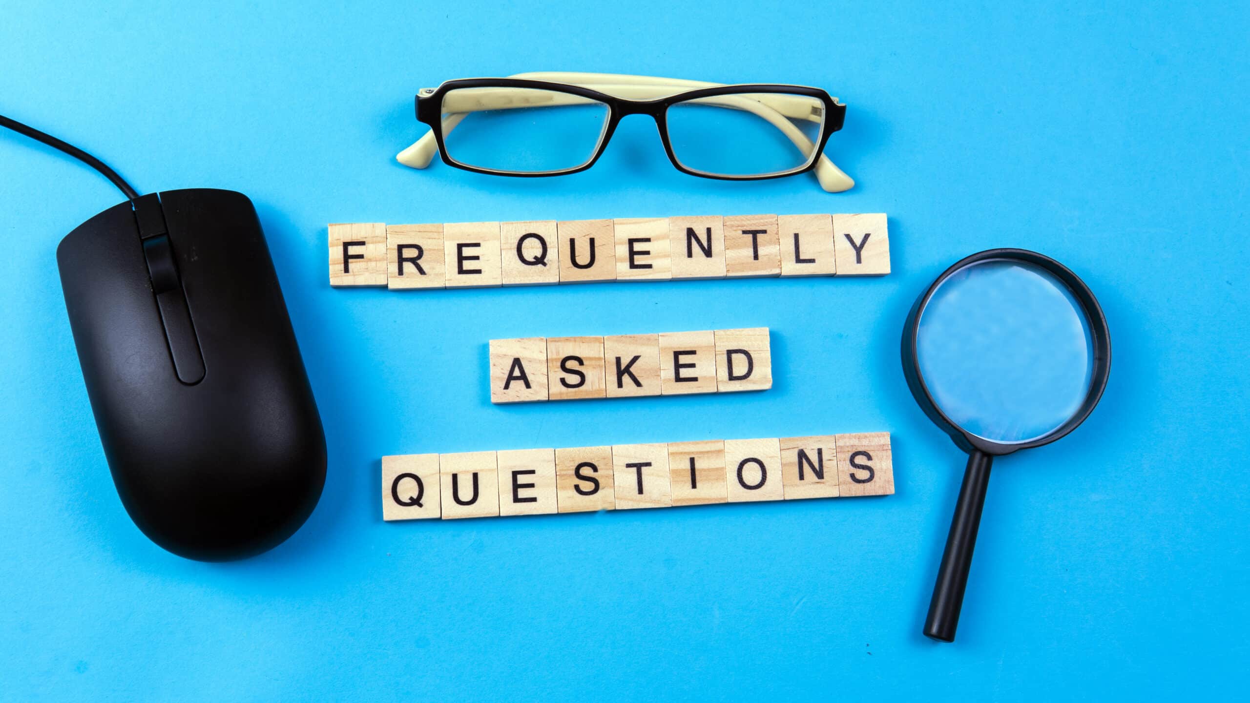 Wooden letter blocks on a bright background, with a magnifying glass and a computer mouse.
